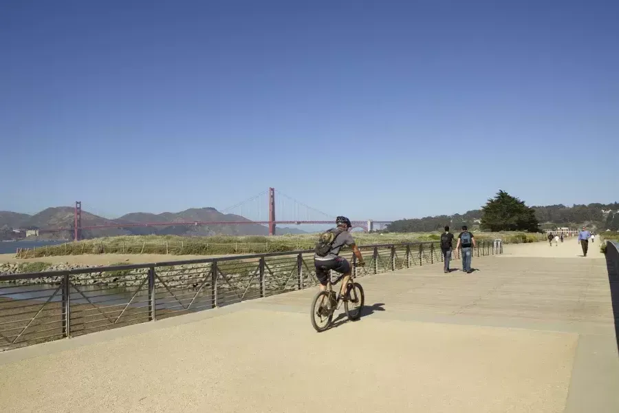 カリフォルニア州サンフランシスコのクリッシーフィールドのトレイル沿いを自転車に乗る男性。